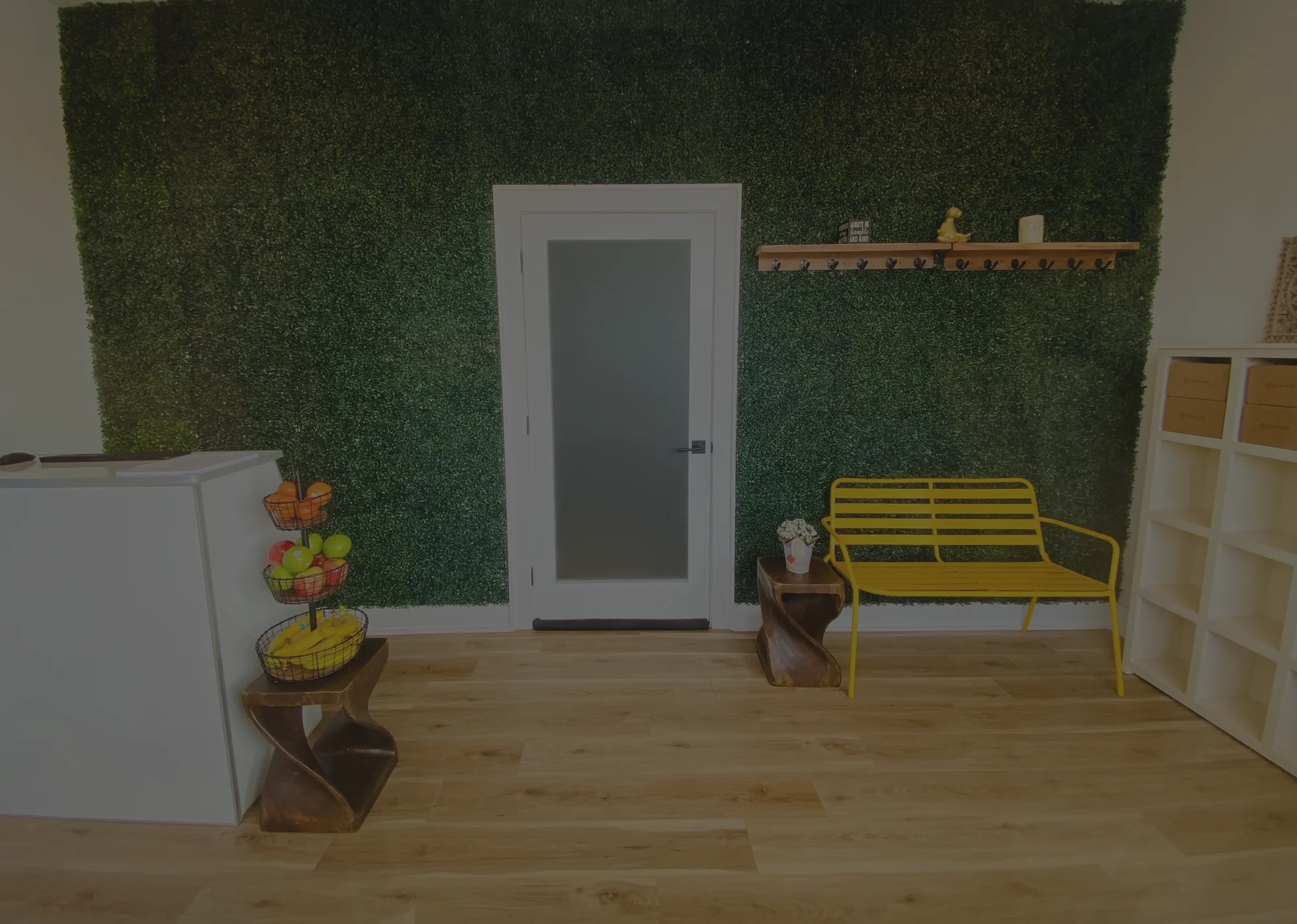 The Lotus Hot Yoga lobby, with its living hedge wall and yellow bench